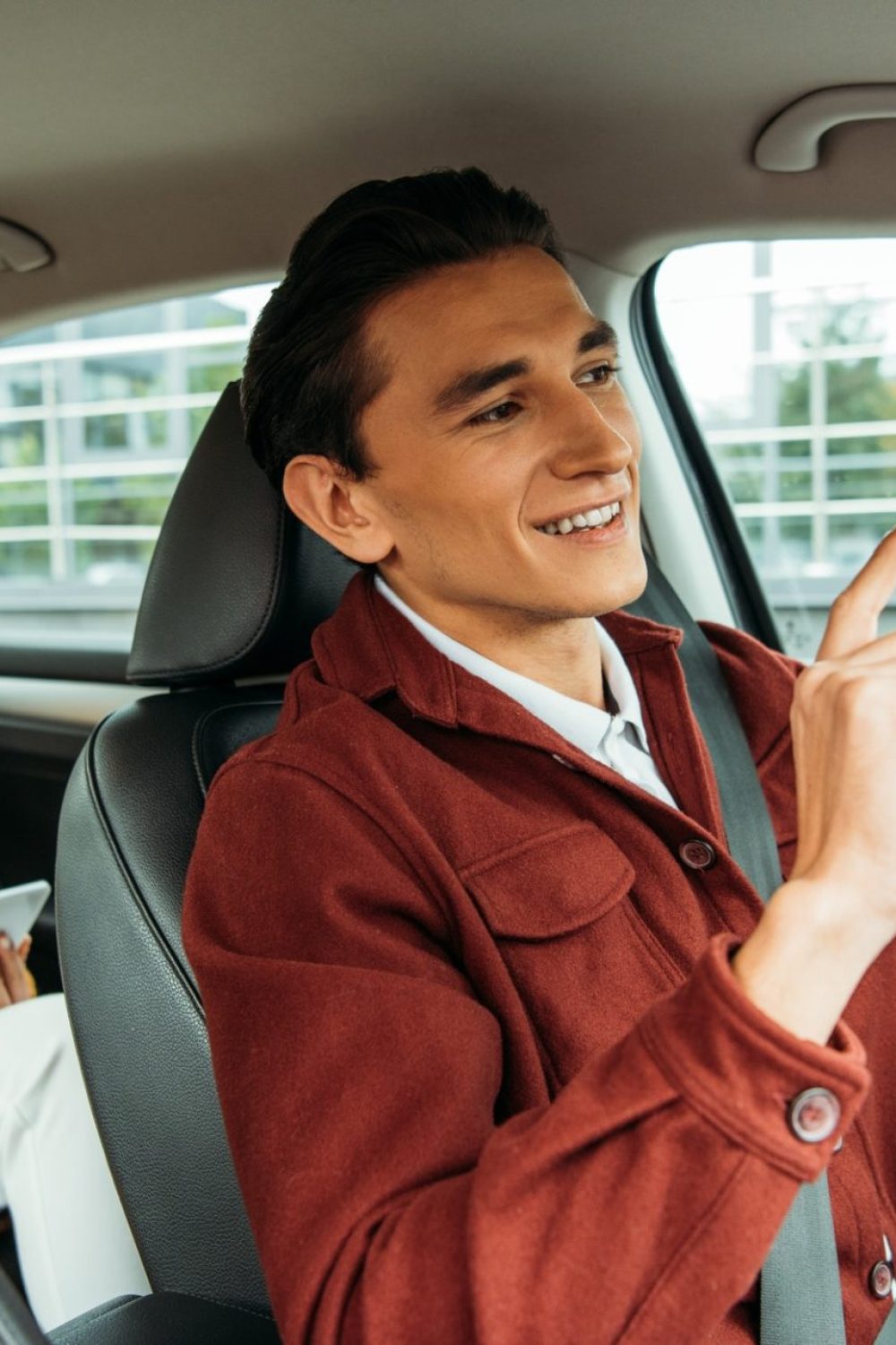 smiling-taxi-driver-and-passenger-with-smartphone-in-car-e1635074849312.jpg